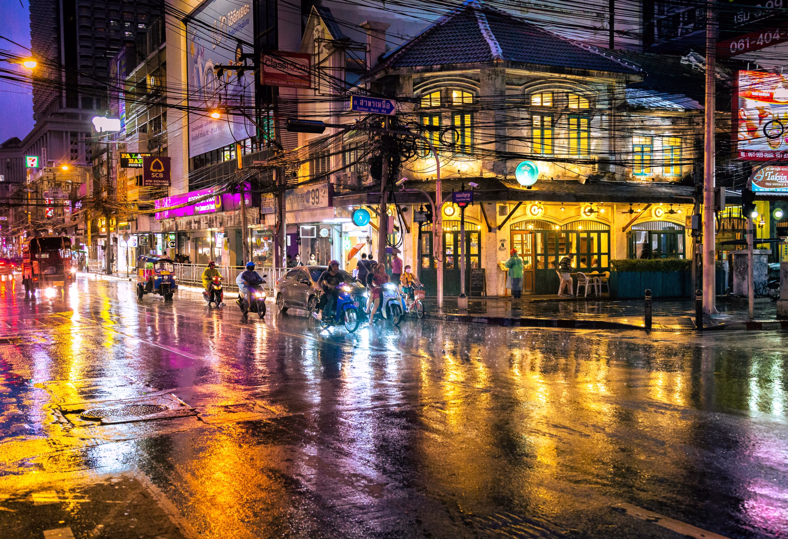 a Bangkok street scene with tuk-tuks and stall